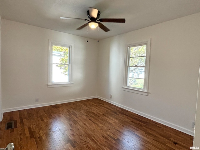 spare room with dark hardwood / wood-style flooring, ceiling fan, and a wealth of natural light