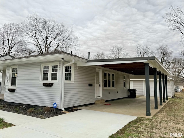 view of front of property featuring entry steps, an attached carport, and concrete driveway