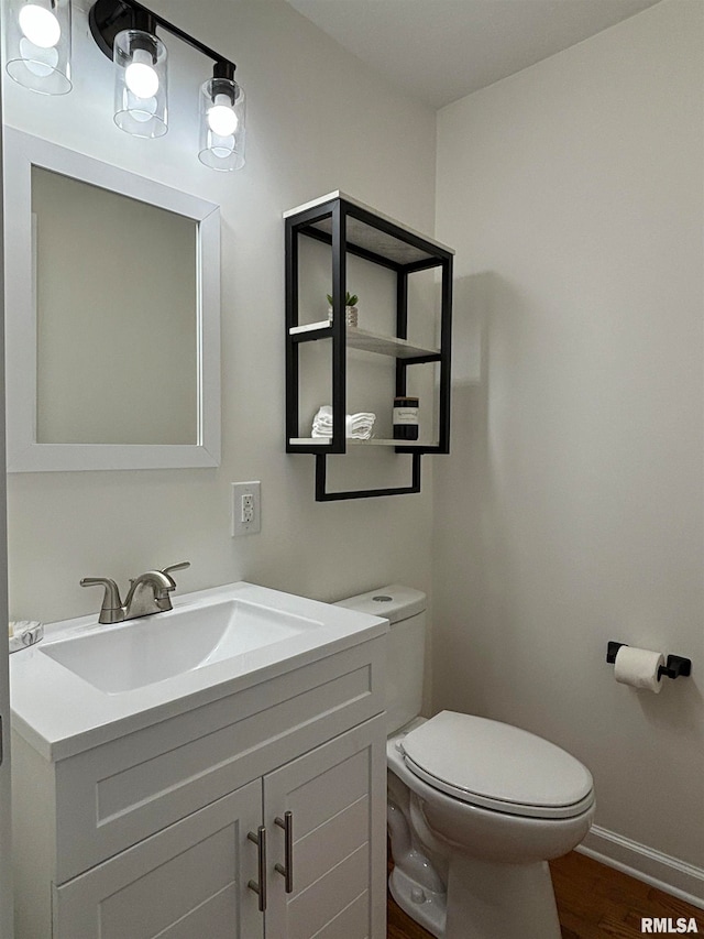 bathroom with vanity, toilet, and hardwood / wood-style floors