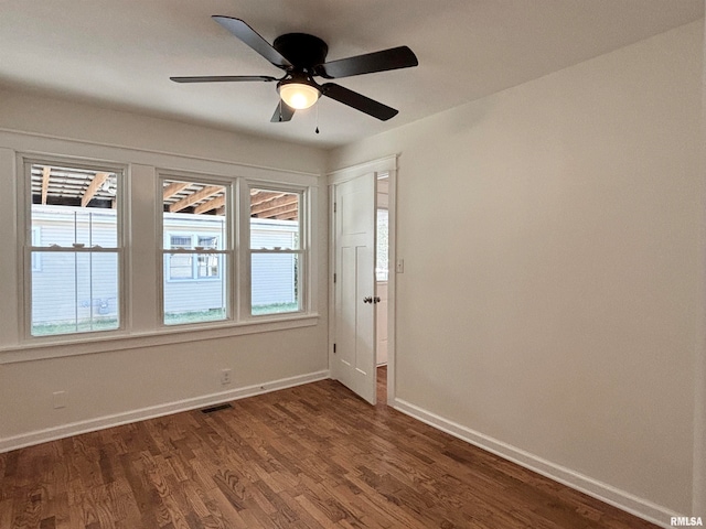 spare room featuring dark wood-type flooring and ceiling fan