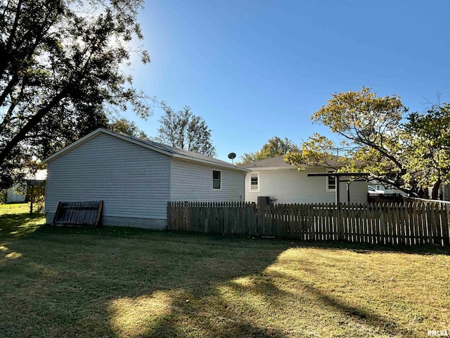 rear view of house with a yard and fence