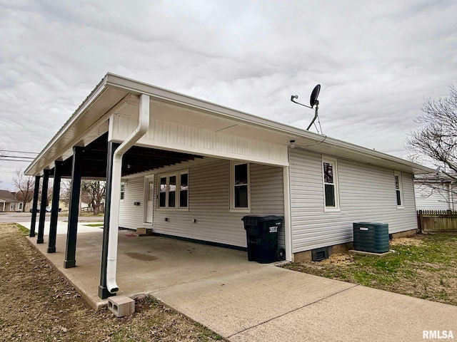 view of side of home featuring a carport, driveway, and central AC unit