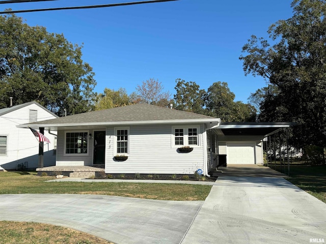 view of front facade with a carport, a front yard, and a garage