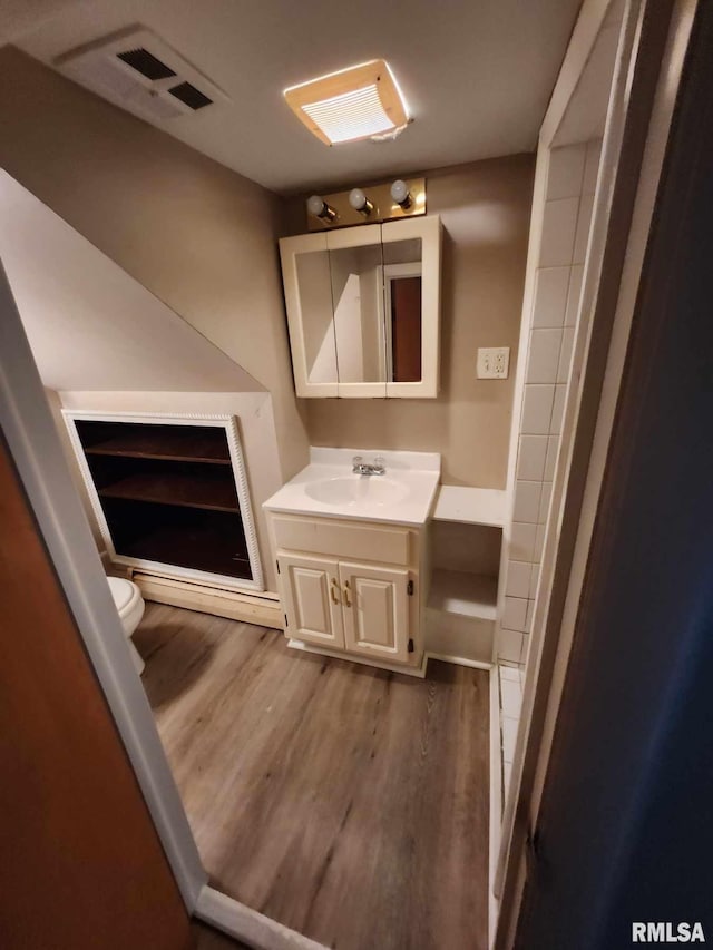 bathroom featuring vanity, toilet, and hardwood / wood-style floors