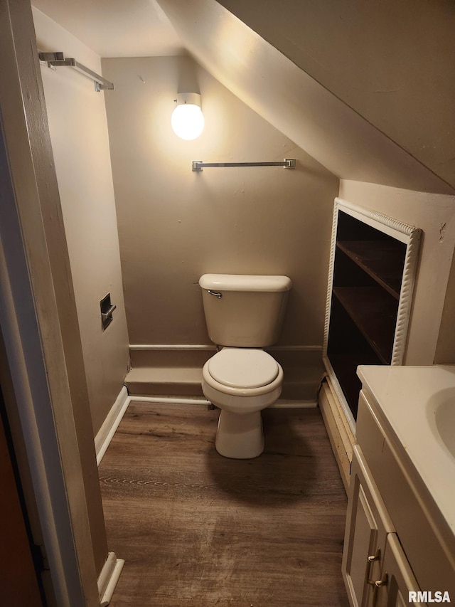 bathroom with vanity, lofted ceiling, hardwood / wood-style flooring, and toilet