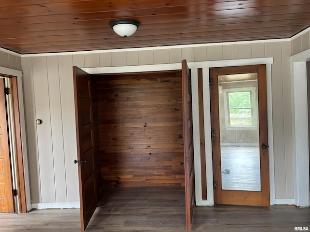 interior space featuring wooden ceiling, dark hardwood / wood-style flooring, and wooden walls