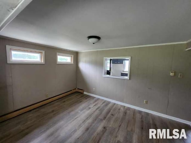 interior space with baseboard heating, ornamental molding, and wood-type flooring