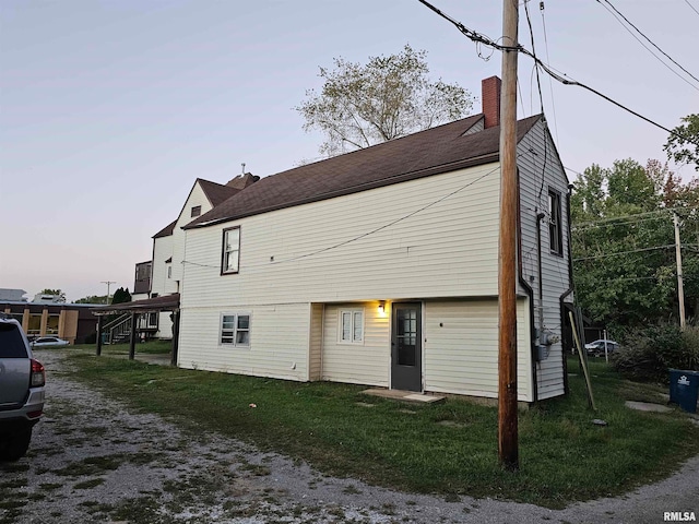 back house at dusk featuring a yard