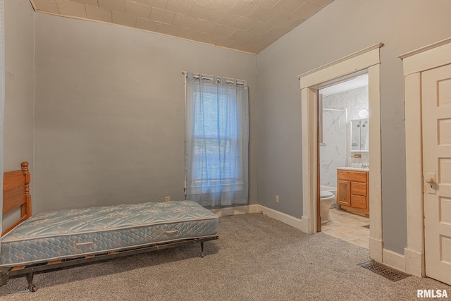 carpeted bedroom featuring ensuite bath