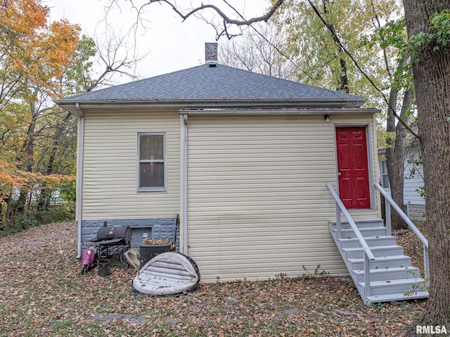 727 N Broadway Ave, Salem, IL 62881 - view of side of property with entry steps, a shingled roof, and a chimney