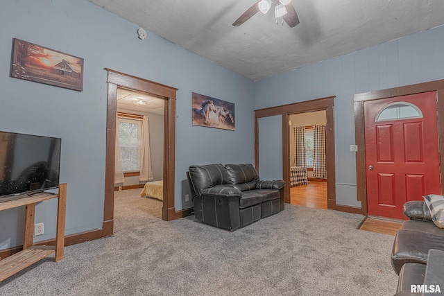 carpeted living room with ceiling fan