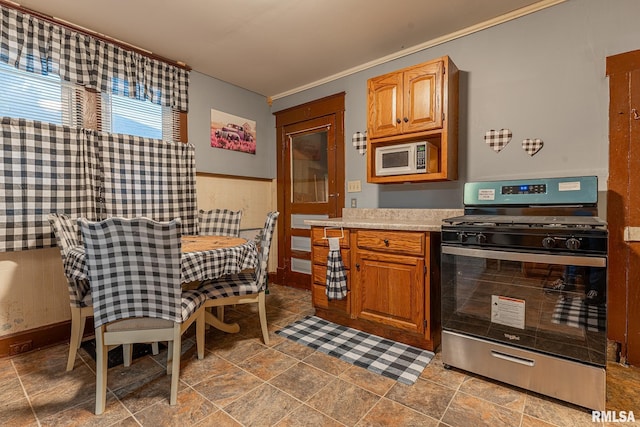 727 N Broadway Ave, Salem, IL 62881 - kitchen with gas range, white microwave, light countertops, and ornamental molding