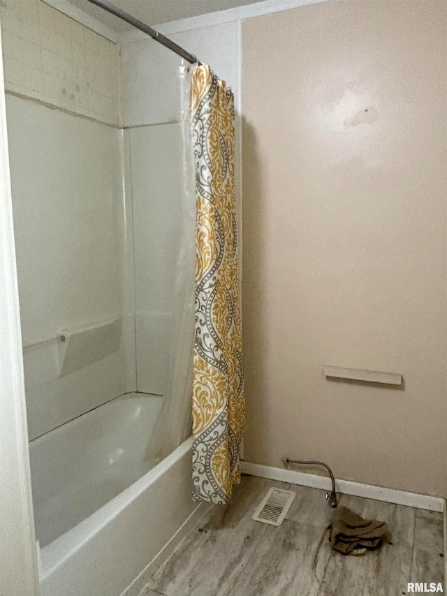 bathroom with shower / bath combo and hardwood / wood-style flooring