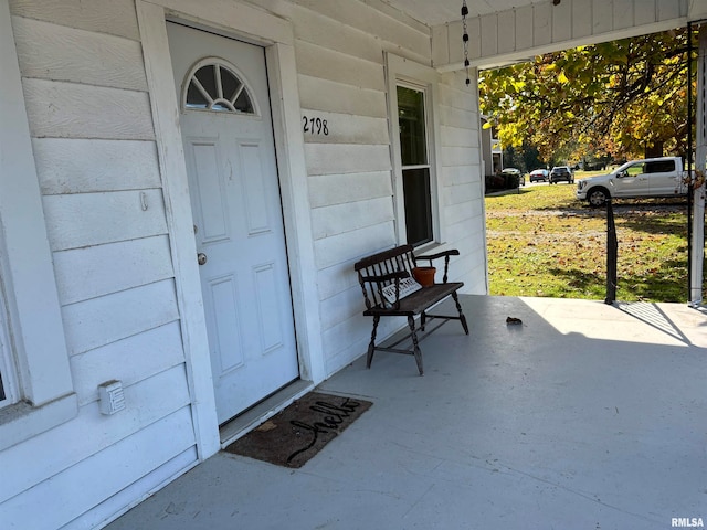 view of exterior entry featuring covered porch