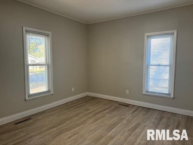 empty room with crown molding and hardwood / wood-style floors