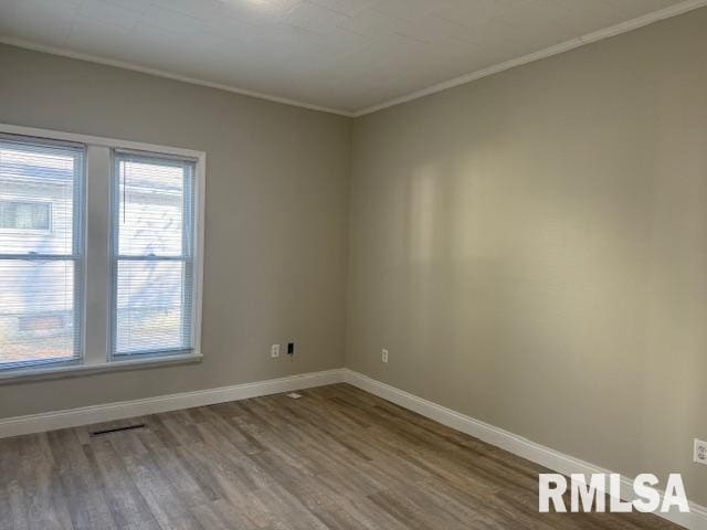 spare room featuring crown molding and hardwood / wood-style flooring