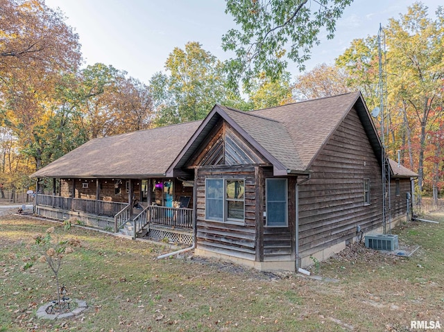 log home with central air condition unit, a front yard, and a porch