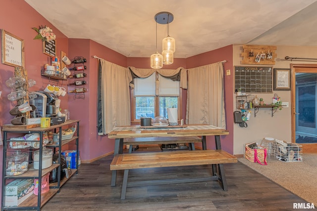 dining area with dark hardwood / wood-style flooring and an inviting chandelier