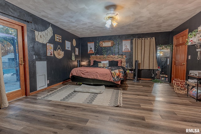 bedroom with access to exterior, hardwood / wood-style flooring, and ceiling fan