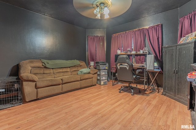 home office with light hardwood / wood-style floors and ceiling fan