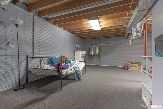 basement featuring brick wall and carpet