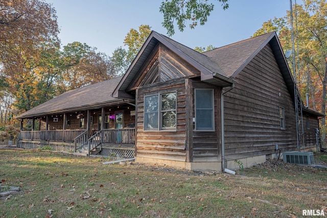 view of front of property featuring covered porch, central AC, and a front lawn