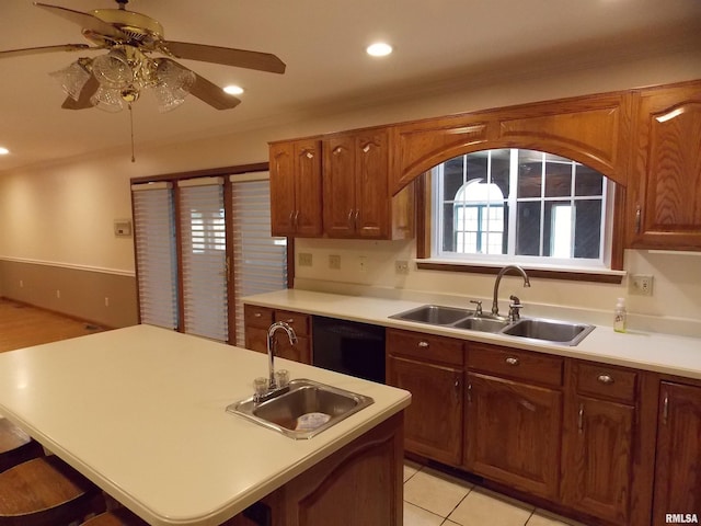 kitchen featuring black dishwasher, light tile patterned flooring, sink, and ceiling fan