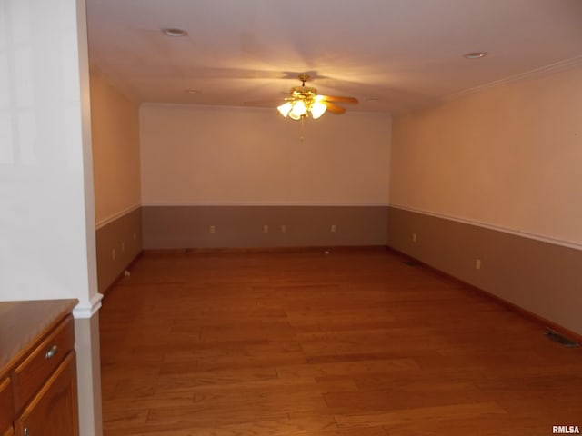 spare room featuring light hardwood / wood-style floors, ornamental molding, and ceiling fan