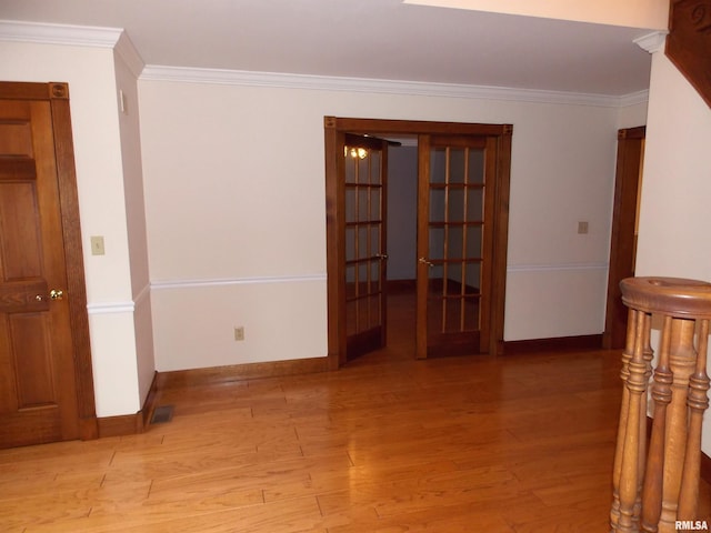 spare room with crown molding and light wood-type flooring