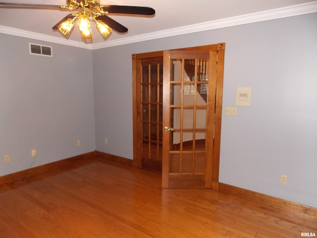 empty room featuring ornamental molding, hardwood / wood-style flooring, and ceiling fan