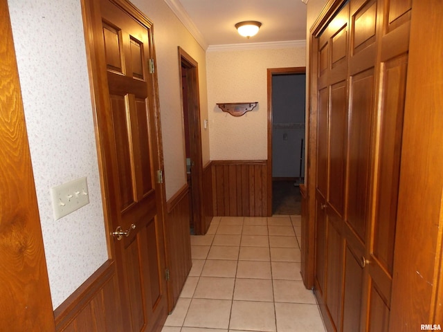 hallway featuring ornamental molding, light tile patterned flooring, and wooden walls