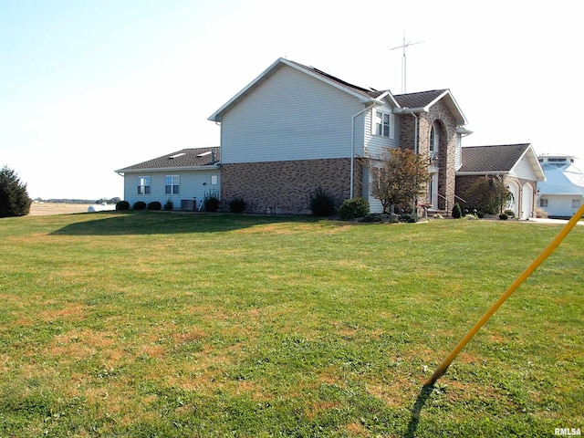 view of side of property with a yard and a garage