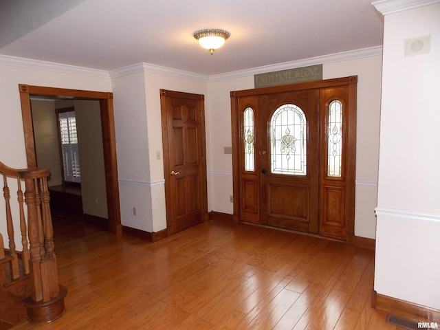 entryway with wood-type flooring and ornamental molding