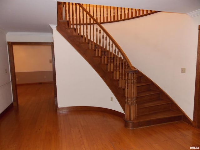 stairway featuring hardwood / wood-style flooring and ornamental molding