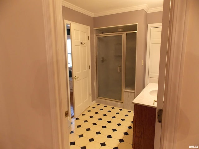 bathroom with vanity, ornamental molding, and an enclosed shower