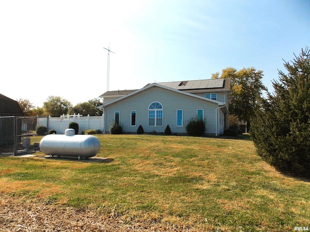 view of side of home featuring a yard and solar panels