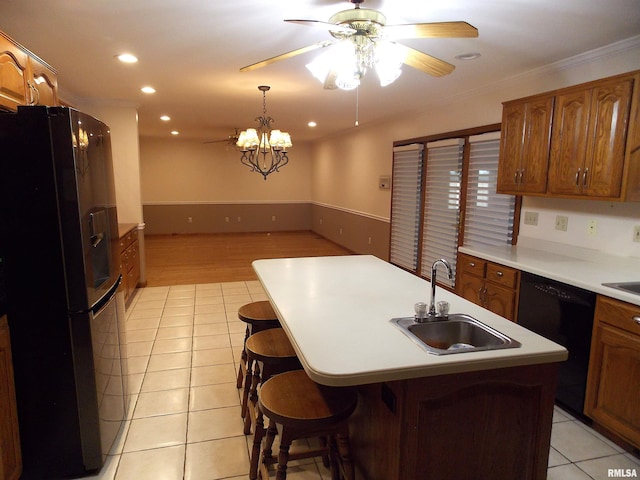 kitchen featuring a kitchen island with sink, black appliances, sink, and light wood-type flooring