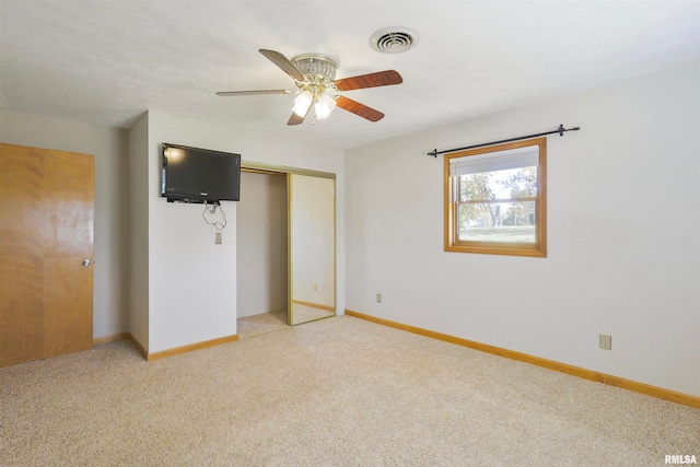 unfurnished bedroom with light carpet, a closet, and ceiling fan