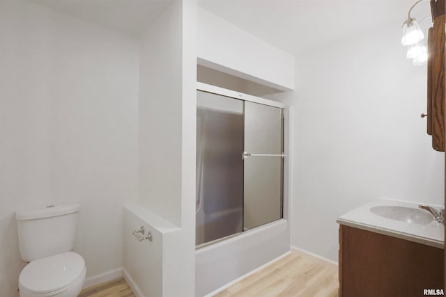 full bathroom with vanity, toilet, hardwood / wood-style flooring, and combined bath / shower with glass door