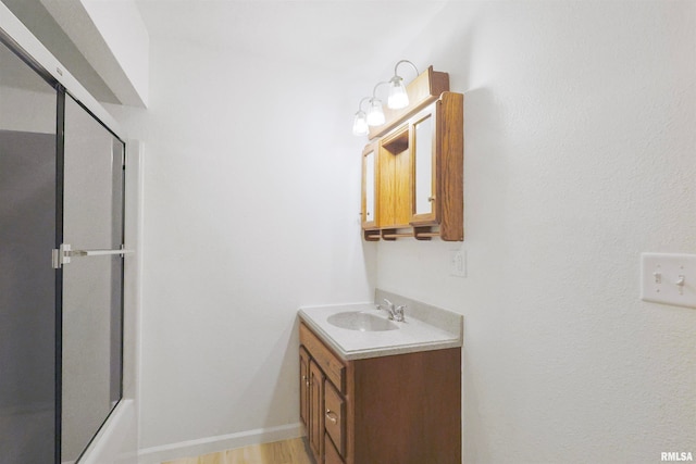 bathroom with shower / bath combination with glass door, vanity, and wood-type flooring