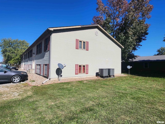 view of side of property featuring a yard and central air condition unit