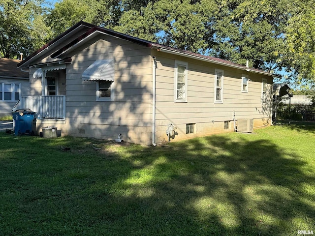 view of side of home with a yard and cooling unit