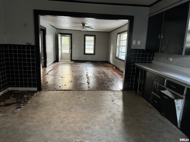 interior space with tile walls, hardwood / wood-style floors, crown molding, and ceiling fan