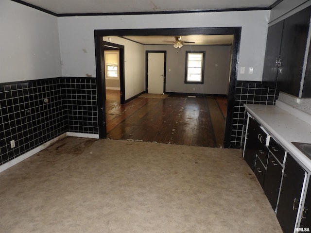 interior space featuring tile walls, dark wood-type flooring, crown molding, and ceiling fan