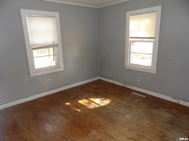 empty room featuring crown molding and dark hardwood / wood-style flooring