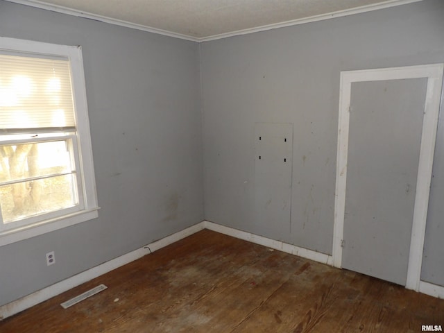 empty room featuring ornamental molding and dark wood-type flooring