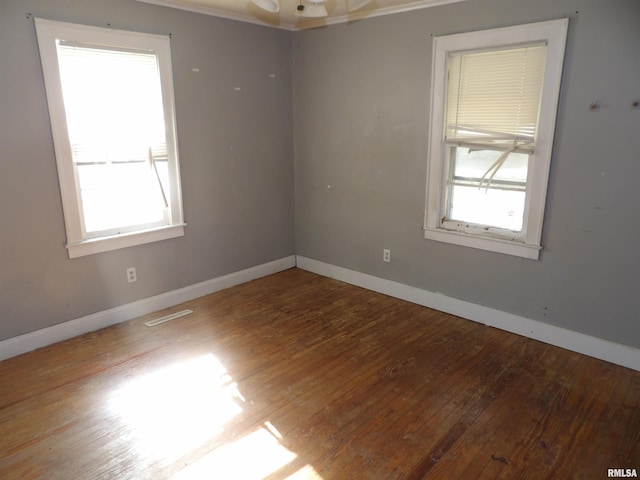 spare room featuring hardwood / wood-style flooring, a healthy amount of sunlight, and ceiling fan