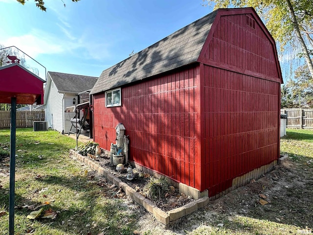 104 Townhouse Dr, Cambria, IL 62915 - view of home's exterior featuring fence, a shingled roof, a gambrel roof, an outbuilding, and a lawn
