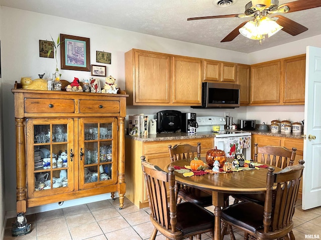 104 Townhouse Dr, Cambria, IL 62915 - kitchen featuring a ceiling fan, visible vents, white electric range, light tile patterned floors, and stainless steel microwave