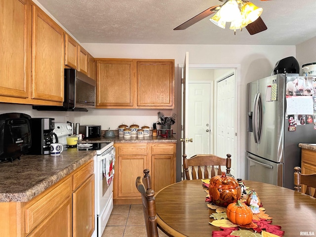 104 Townhouse Dr, Cambria, IL 62915 - kitchen with light tile patterned flooring, white electric range oven, stainless steel fridge, a textured ceiling, and a ceiling fan